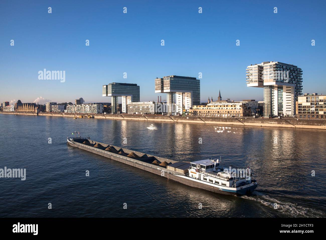 Schüttgutfrachter auf dem Rhein, Kranhäuser im Rheinauer Hafen, Köln, Deutschland. Schuettgutfrachter auf dem Rhein, Kranhaeuser im Rheinauhafen, Köln, De Stockfoto
