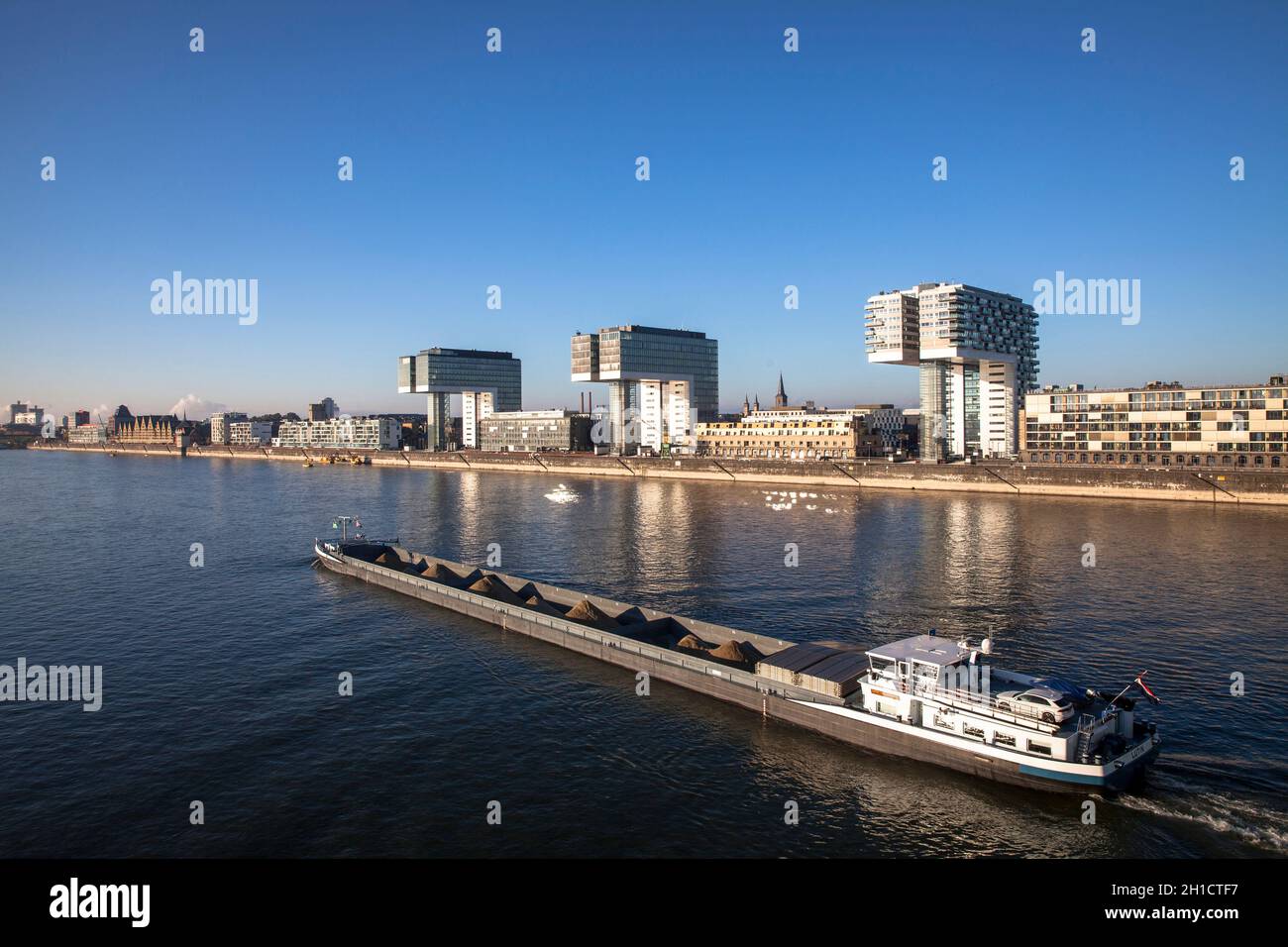 Schüttgutfrachter auf dem Rhein, Kranhäuser im Rheinauer Hafen, Köln, Deutschland. Schuettgutfrachter auf dem Rhein, Kranhaeuser im Rheinauhafen, Köln, De Stockfoto