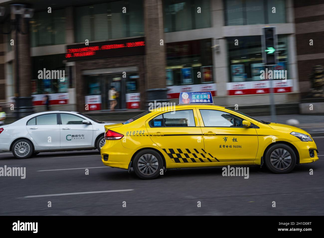 Chongqing, China - August 2019: Gelbes Taxi, das auf der belebten und überlasteten Straße fährt Stockfoto