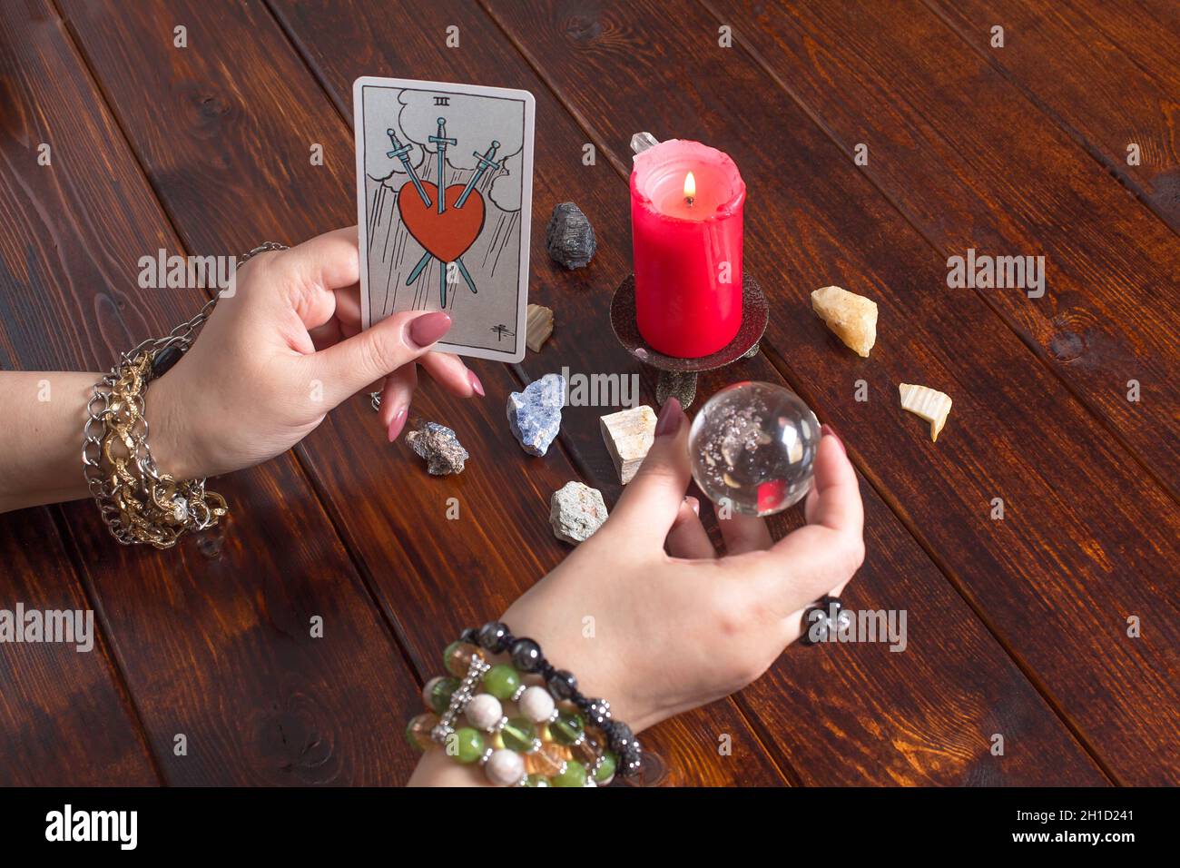 Bangkok, Thailand, März.15.20.Ein Wahrsager hält einen magischen Ball und eine Tarot-Karte mit einem Herzen.der Zigeuner legt Tarot-Karten aus und rät für das Fu Stockfoto