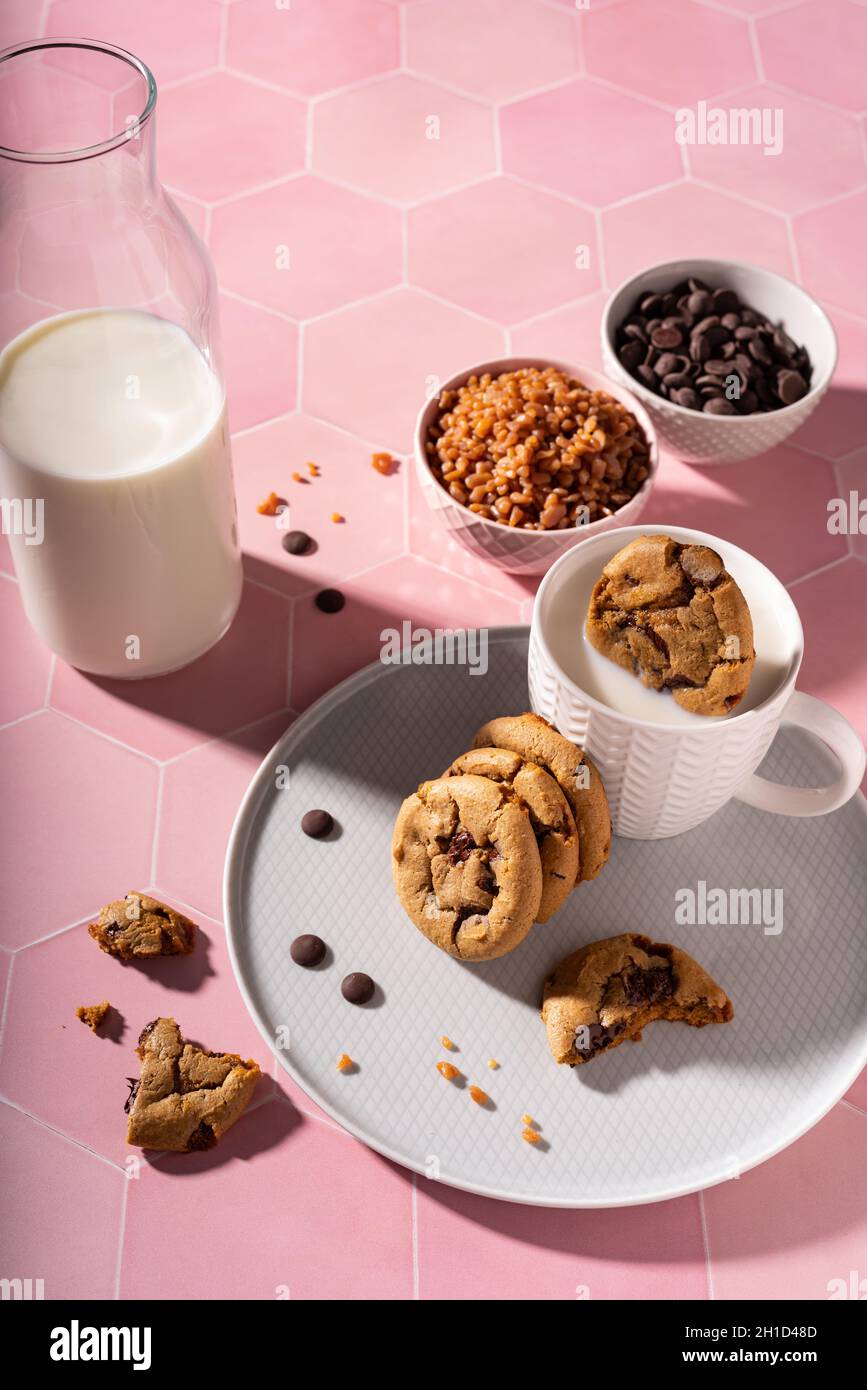 Frische Schokoladenkekse, die in einer Tasse Milch spritzen Stockfoto