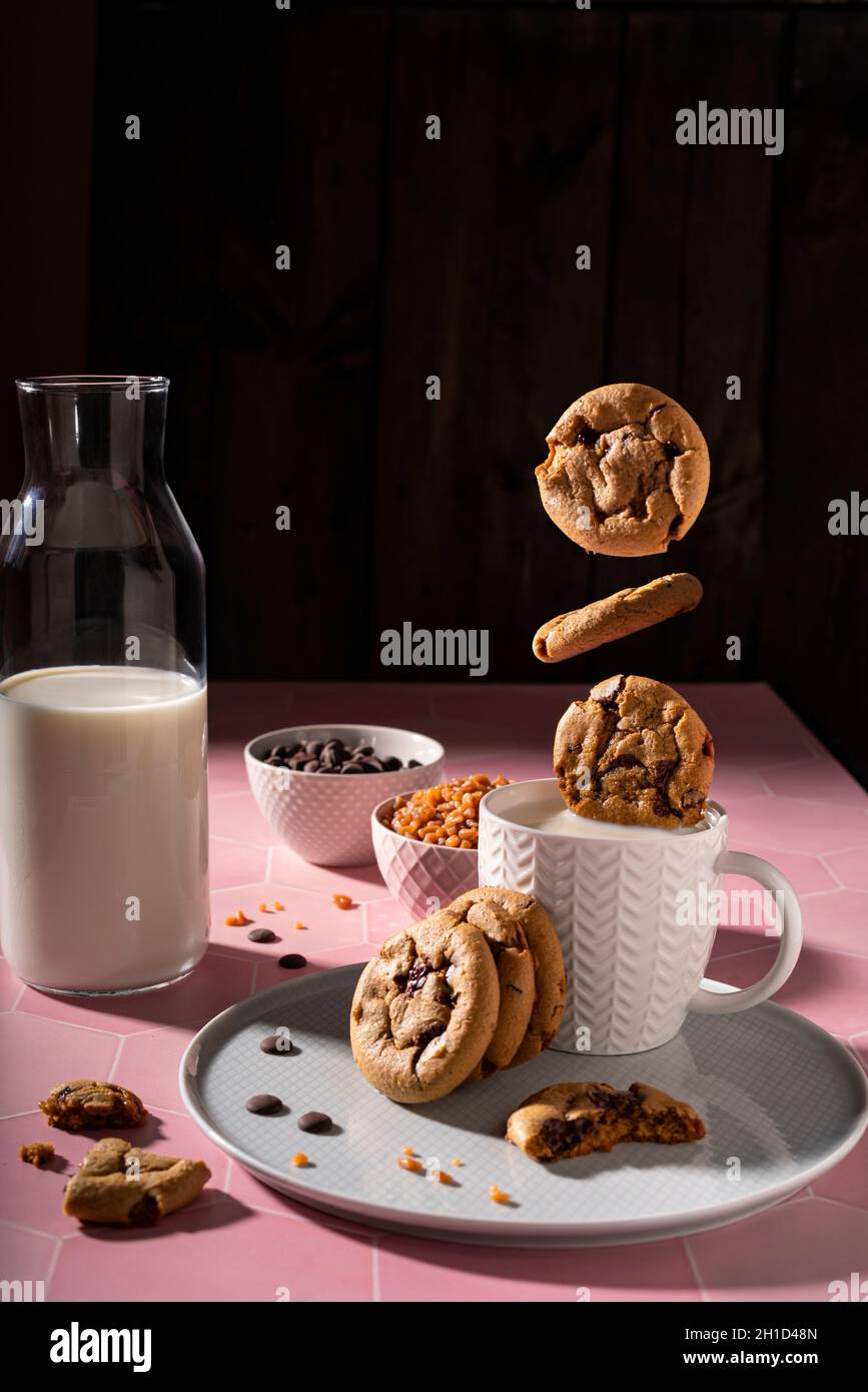 Frische Schokoladenkekse, die in einer Tasse Milch spritzen Stockfoto