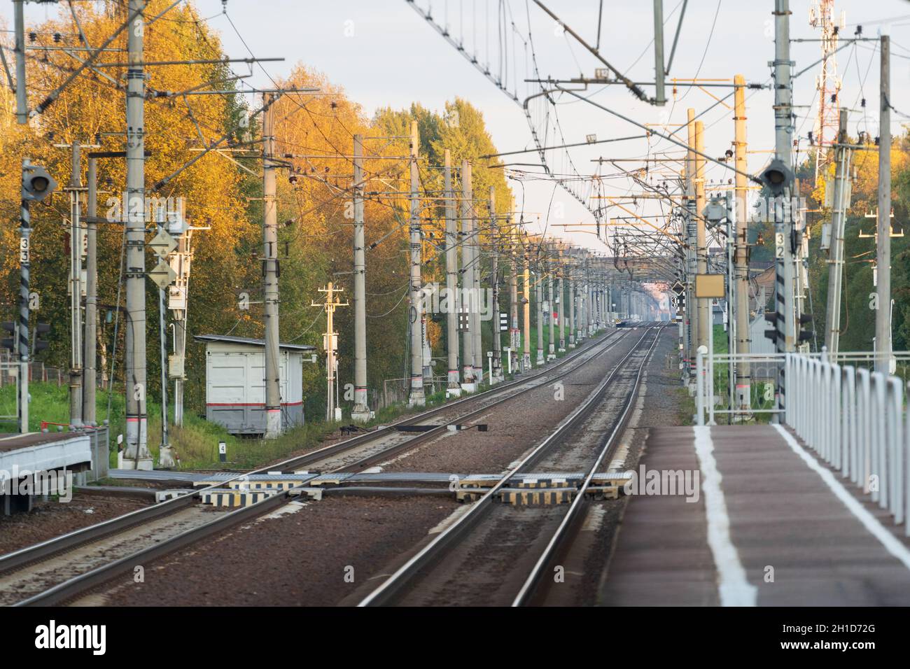 Bahnhof mit Bahngleisen, Herbstsaison. Perspektive der elektrifizierten Hochgeschwindigkeitsbahn Stockfoto