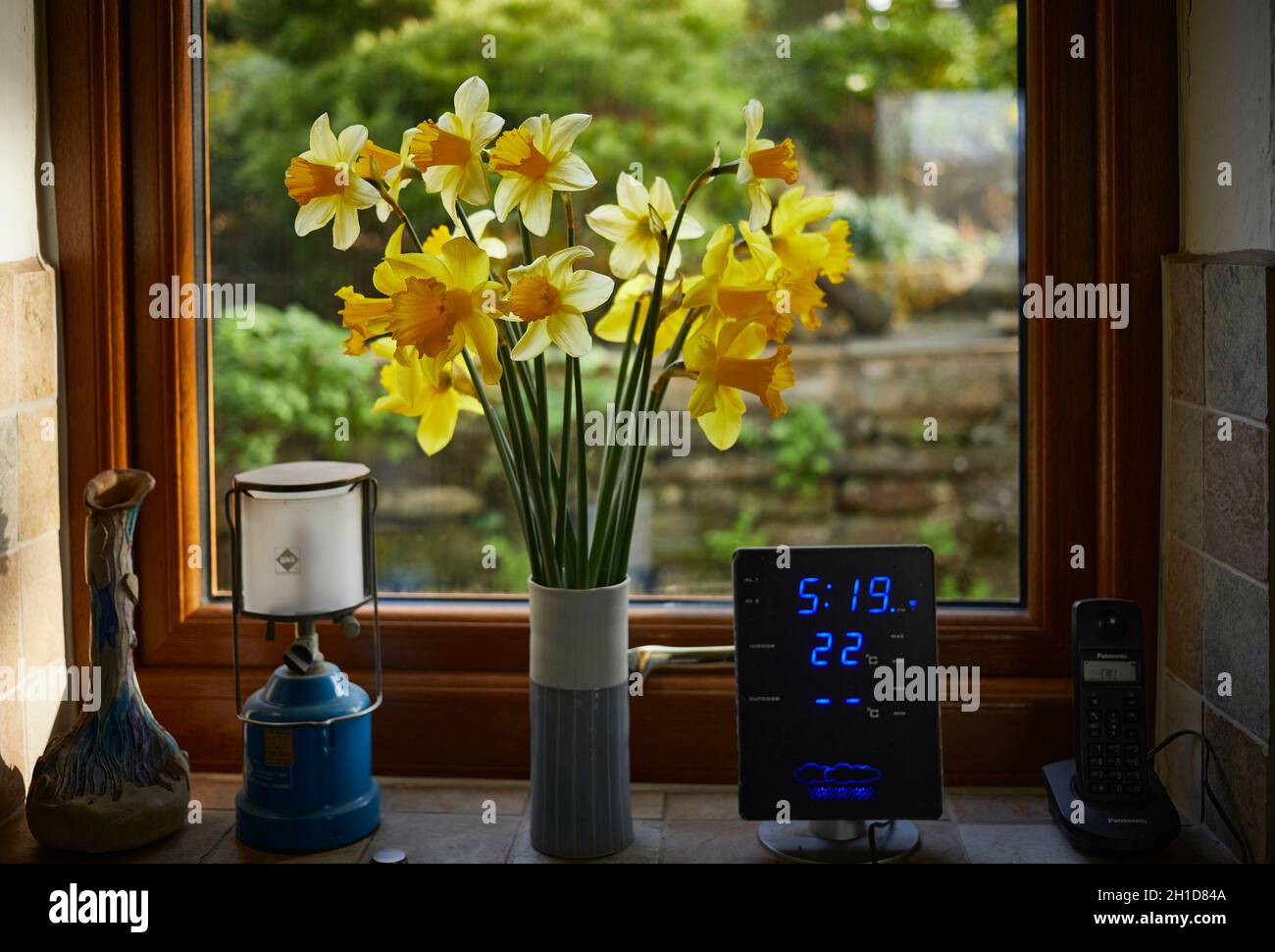 Eine Vase aus frühlingshaften Narzissen auf einer Fensterbank Stockfoto