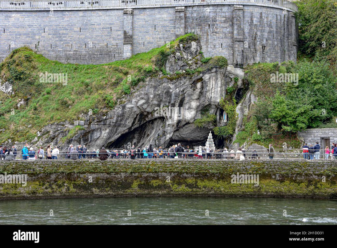 Lourdes, Frankreich - 9. Oktober 2021: Die Grotte von Massabielle von der anderen Seite des Flusses Gave de Pau in Lourdes aus gesehen Stockfoto
