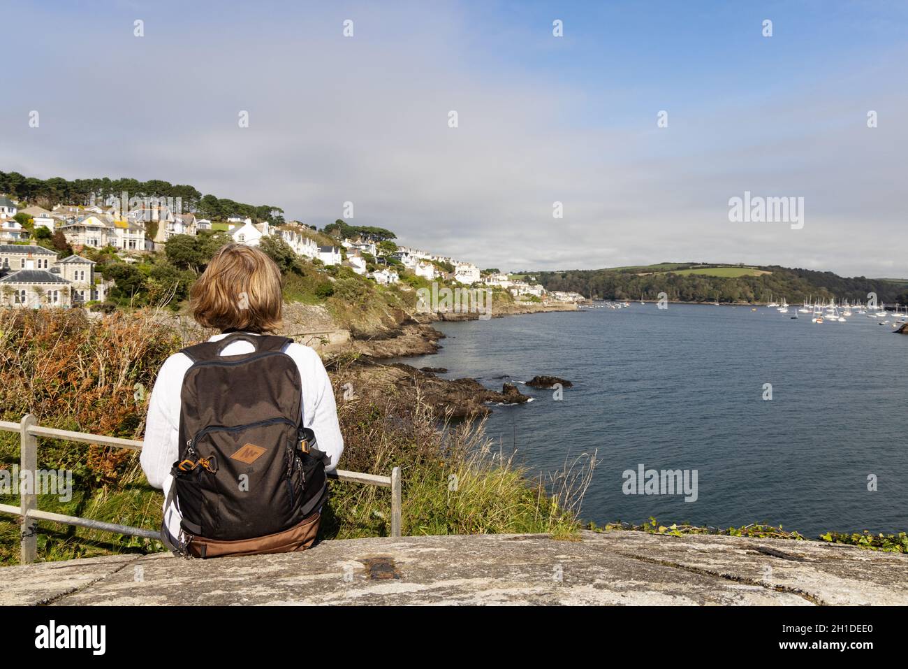 Ein Spaziergänger, der den South West Coast Path oder Cornwall Coastal Path in Fowey mit Blick auf die Flussmündung des Fowey, Cornwall, Großbritannien, zu Fuß erreicht Stockfoto