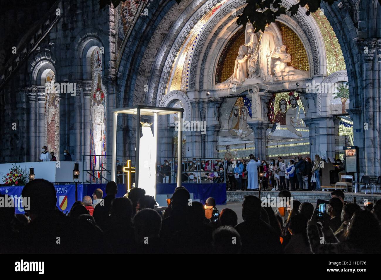 Lourdes, Frankreich - 9. Oktober 2021: Während der Marian Facklight Prozession in der Rosenkranzbasilika i wird eine Statue der Jungfrau Maria in die Menge getragen Stockfoto