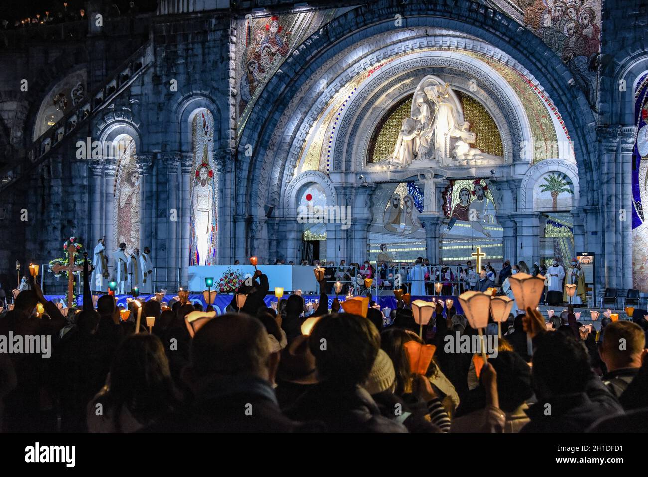 Lourdes, Frankreich - 9. Oktober 2021: Pilger nehmen an der Marienfackelprozession in der Rosenkranzbasilika in Lourdes Teil Stockfoto