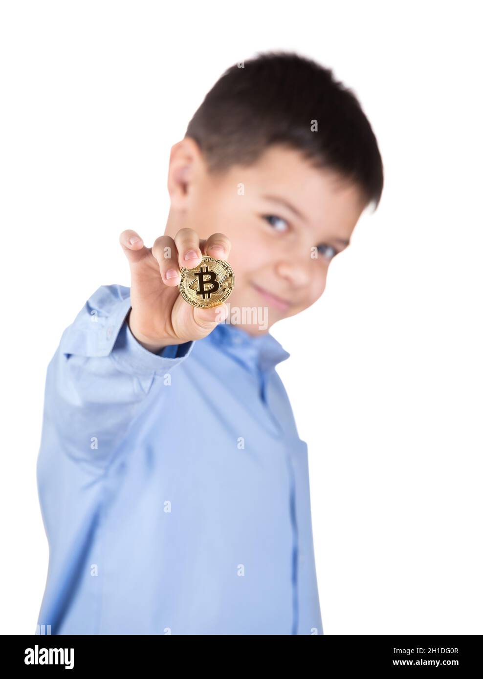Junge in blauem Hemd hält Beatcoin in seiner ausgestreckten Hand und lächelt. Isoliert auf weißem Hintergrund. Unscharfer Hintergrund. Das Konzept von Bitcoin als Stockfoto