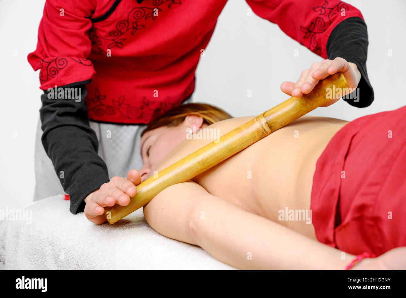 Frau mit Bambusstäbchen Massage im Day Spa. Stockfoto