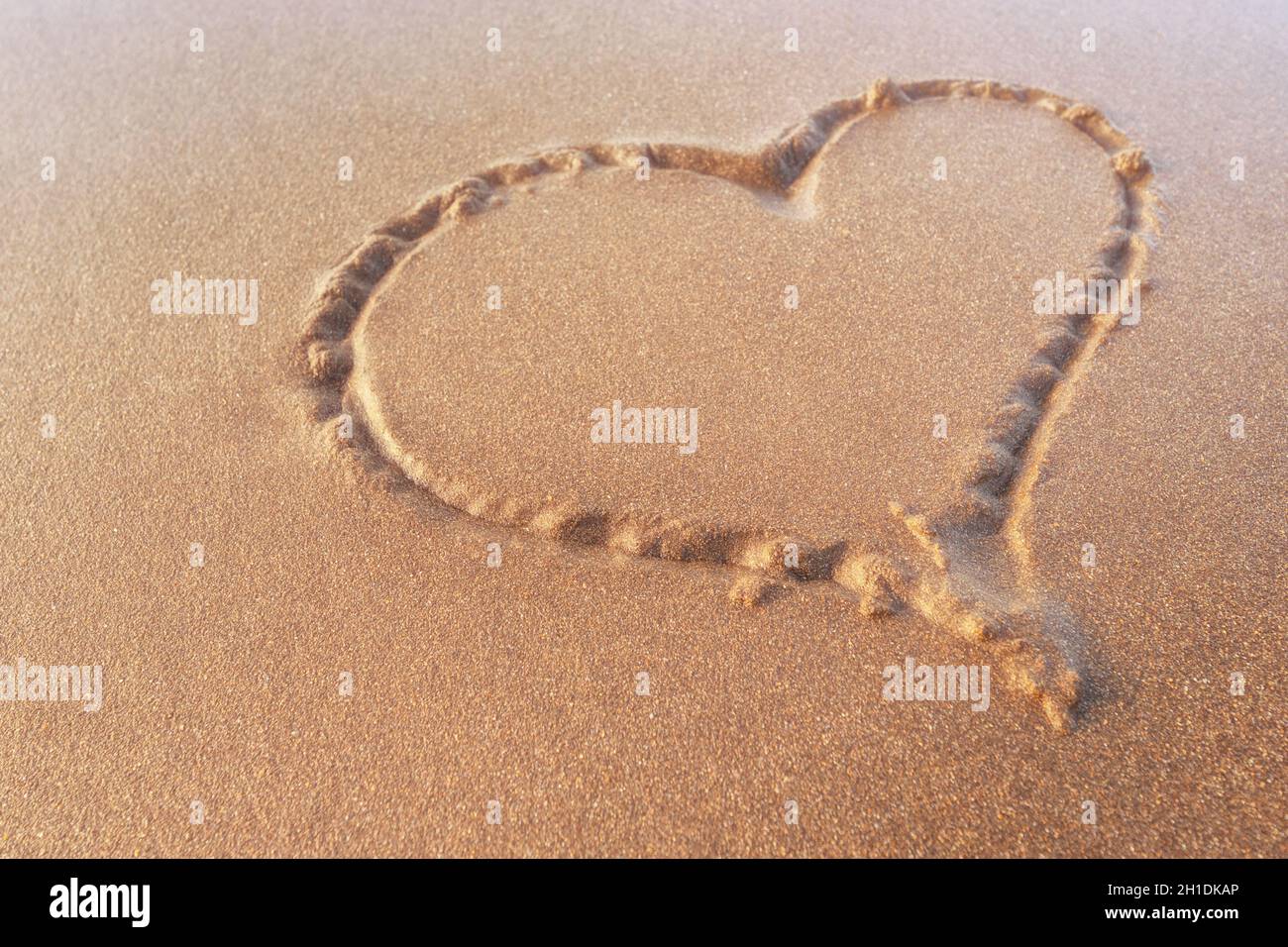 Herz im Sand auf den Strand gezogen. Liebe Konzept. Stockfoto