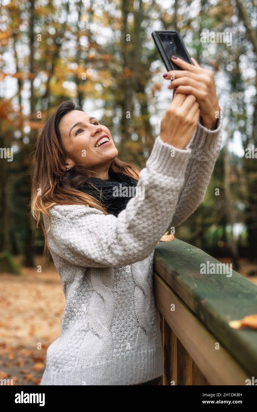 Portrait von glücklichen Frau, die selfie im Herbst Park voller gelbe Blätter. Stockfoto