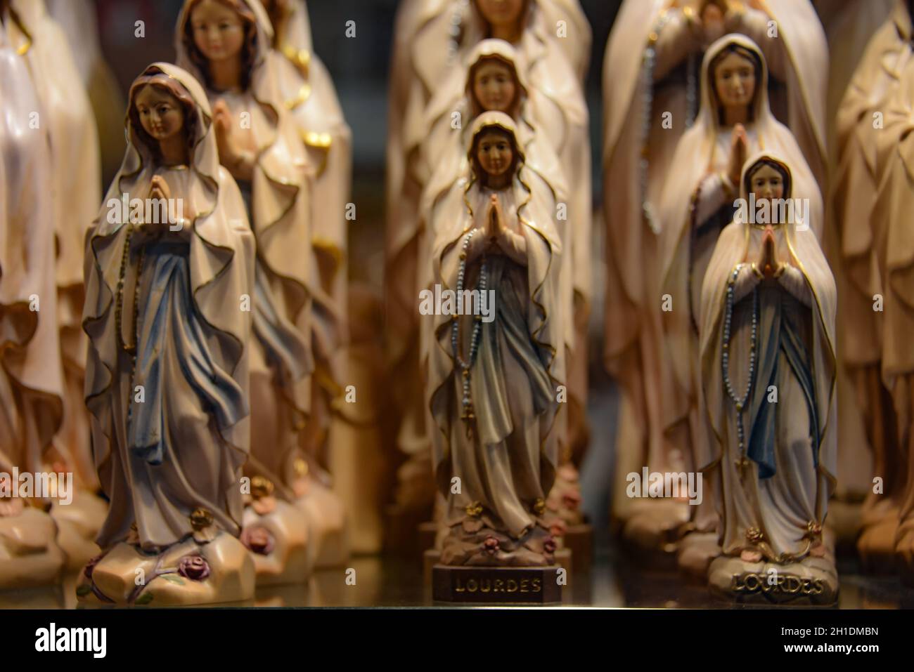 Lourdes, Frankreich - 9 Oct 2021: Figurenstatuen der Jungfrau Maria, erhältlich in einem Souvenirladen in Lourdes, Frankreich Stockfoto