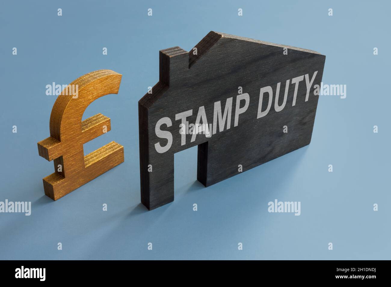 Hausmodell mit Aufschrift Stempelsteuer und Pfundzeichen. Stockfoto