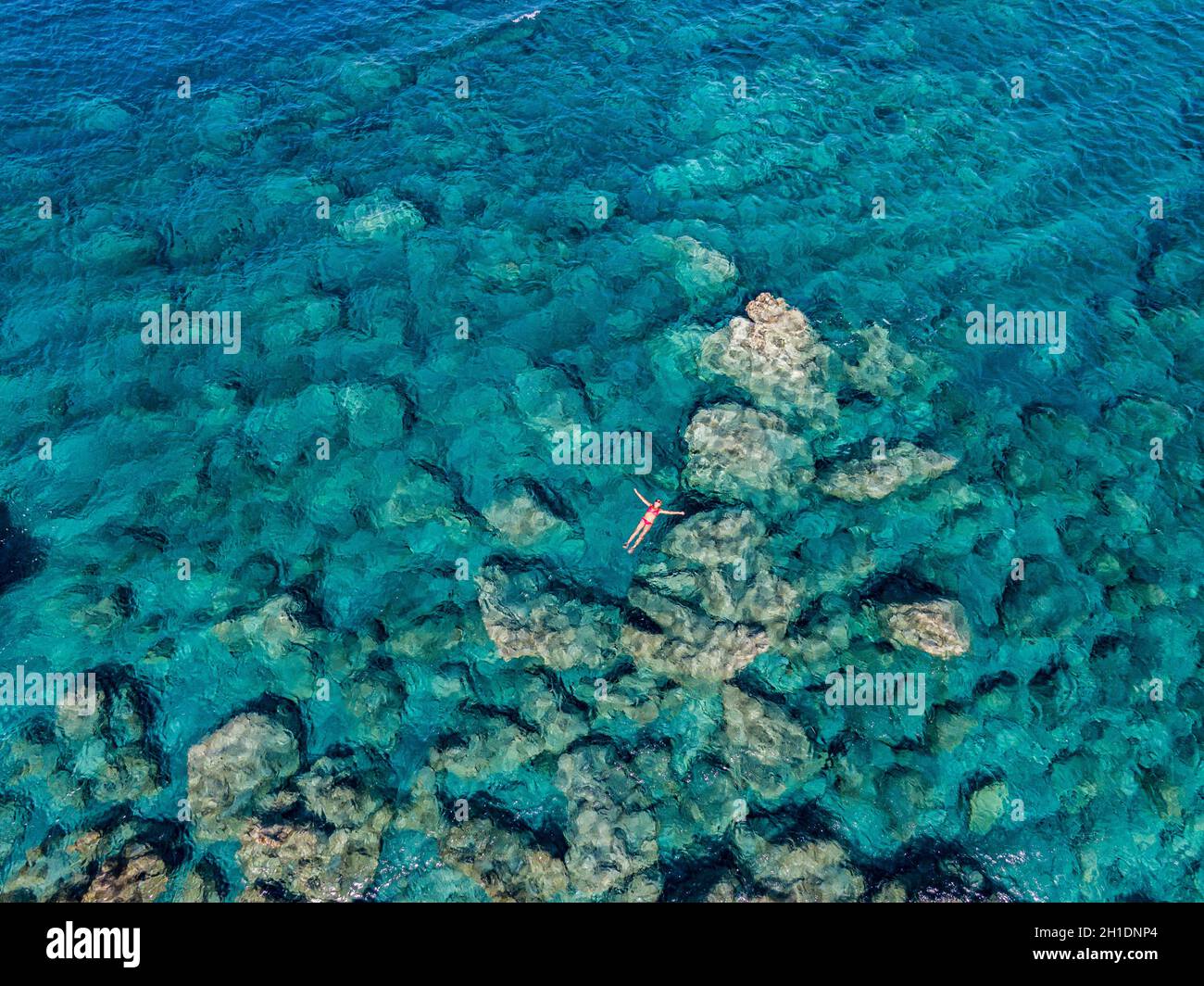 Luftaufnahme der transparenten Meeresoberfläche mit nicht erkennbaren Menschen, die im Meer schwimmen, Amorgos, griechenland Stockfoto