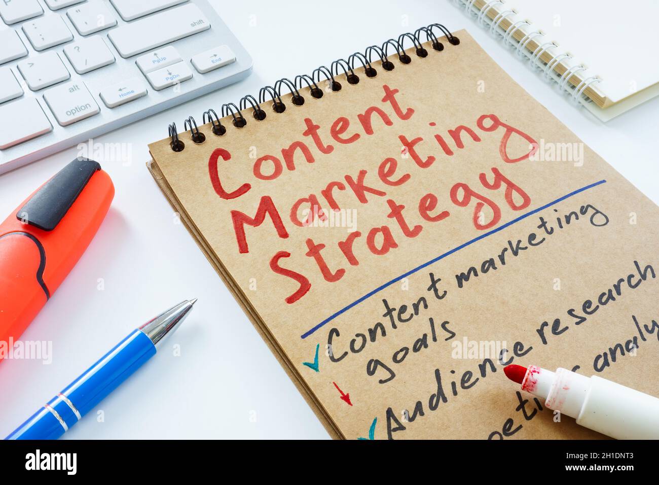 Handschriftliche Marketingstrategie und Tastatur für Inhalte. Stockfoto