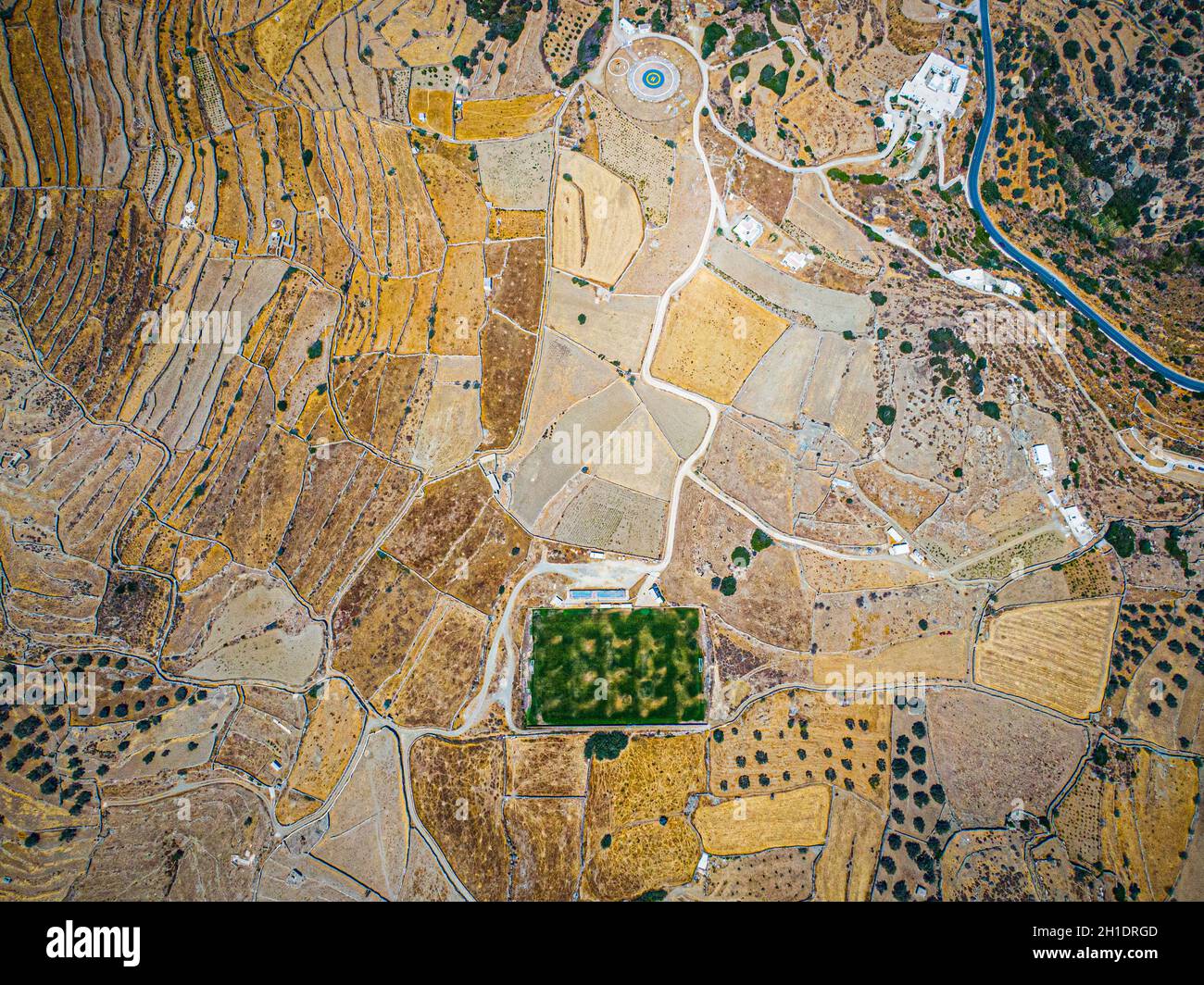 Luftaufnahme auf einem grünen Fußballplatz während der Dürre auf der Insel sifnos, Griechenland Stockfoto