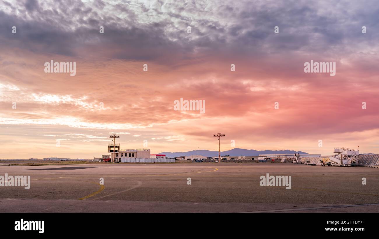 Leerer, verlassener Flughafen mit zerstörten Gebäuden ohne Flugzeuge wegen Coronavirus oder Covid 19 Pandemien und Flugbeschränkungen bei schönem Sonnenuntergang Stockfoto