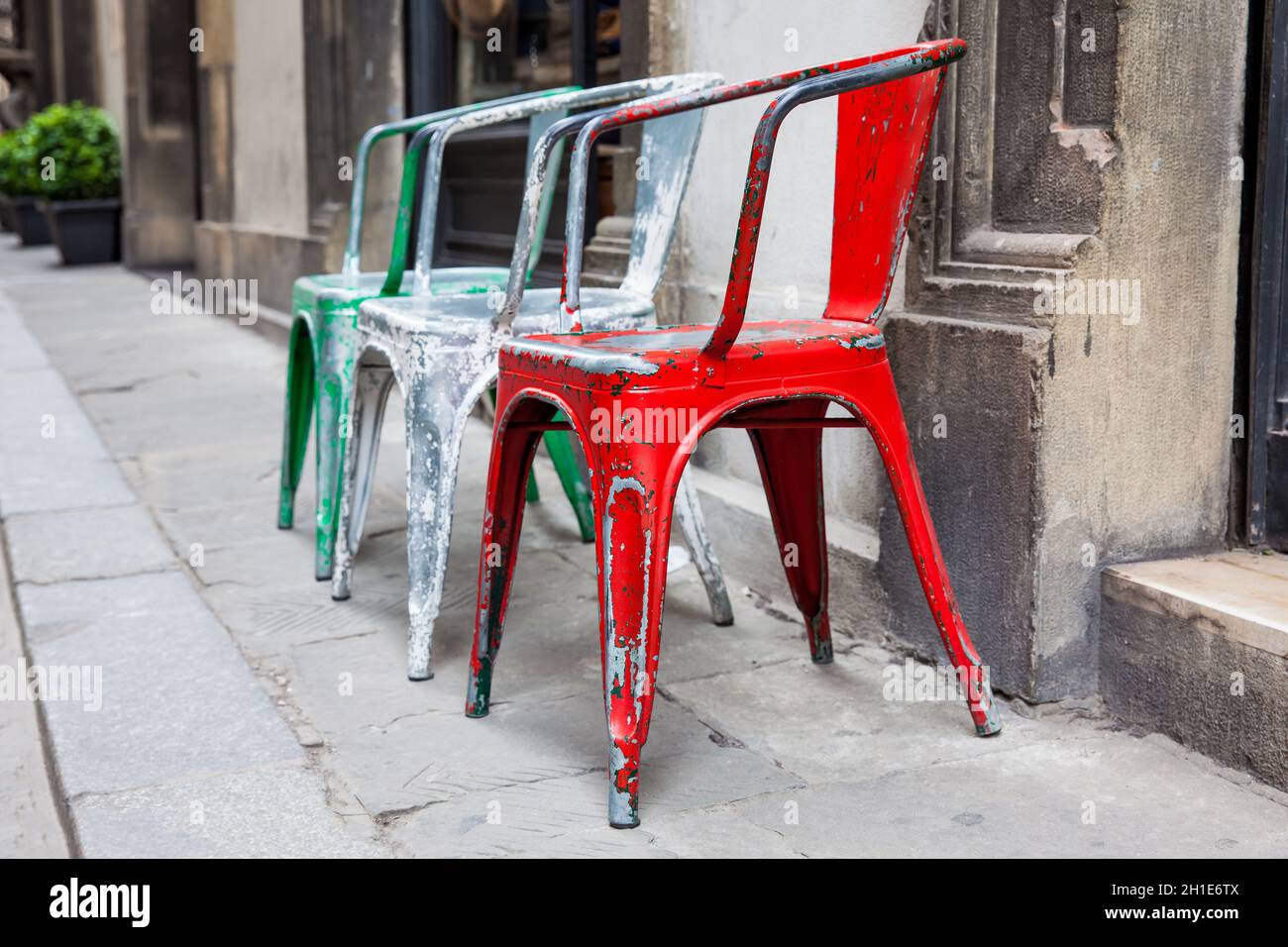 Drei Leere klapprigen bunte Stühle an die historischen Straßen von Florenz Stockfoto