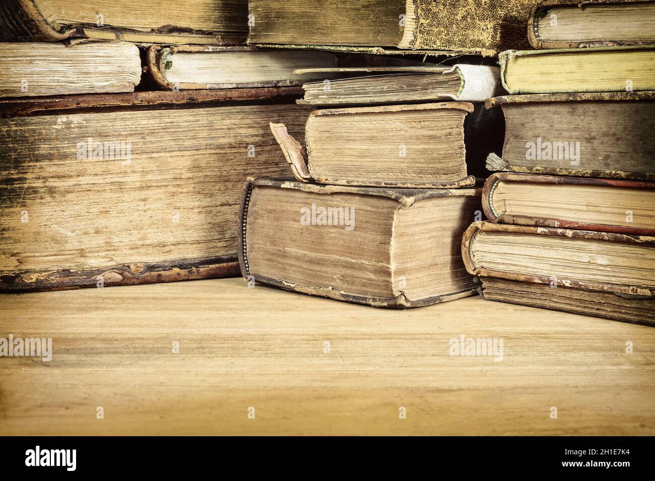 Sepiafarbtes Bild von alten Büchern auf einem Holztisch Stockfoto