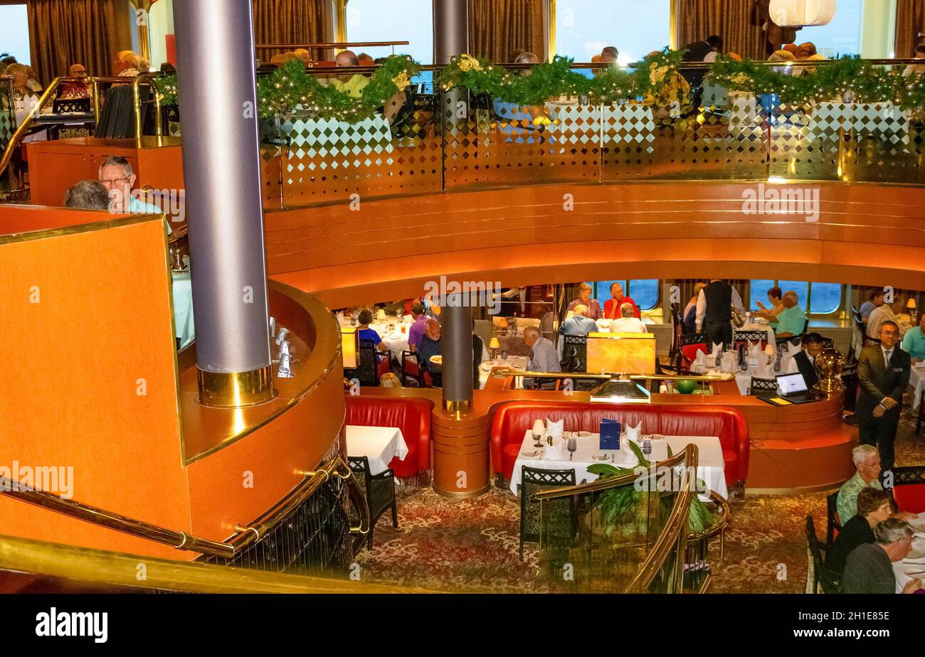 Willemstad, Curacao, Niederlande - 5. Dezember 2019: Die Leute beim Abendessen im Grande Restaurant und Tische mit Gerichten auf der luxuriösen Holland Amerika Kreuzfahrt Stockfoto