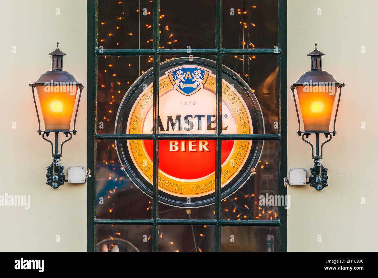 AMSTERDAM, NIEDERLANDE - 16. MAI 2014: Beleuchtetes Schild mit dem niederländischen Amstel Beer-Logo hinter einem Fenster eines alten Amsterdamer Pubs Stockfoto