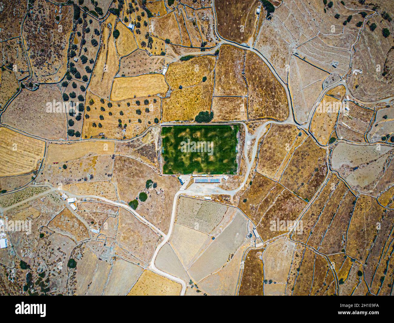 Luftaufnahme auf einem grünen Fußballplatz während der Dürre auf der Insel sifnos, Griechenland Stockfoto