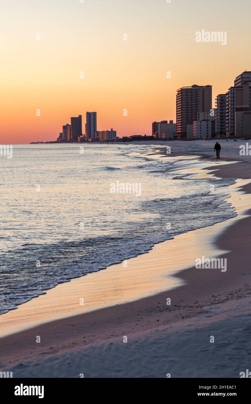 Mann, der am Strand bei Sonnenuntergang in Gulf Shores, Alabama, läuft Stockfoto