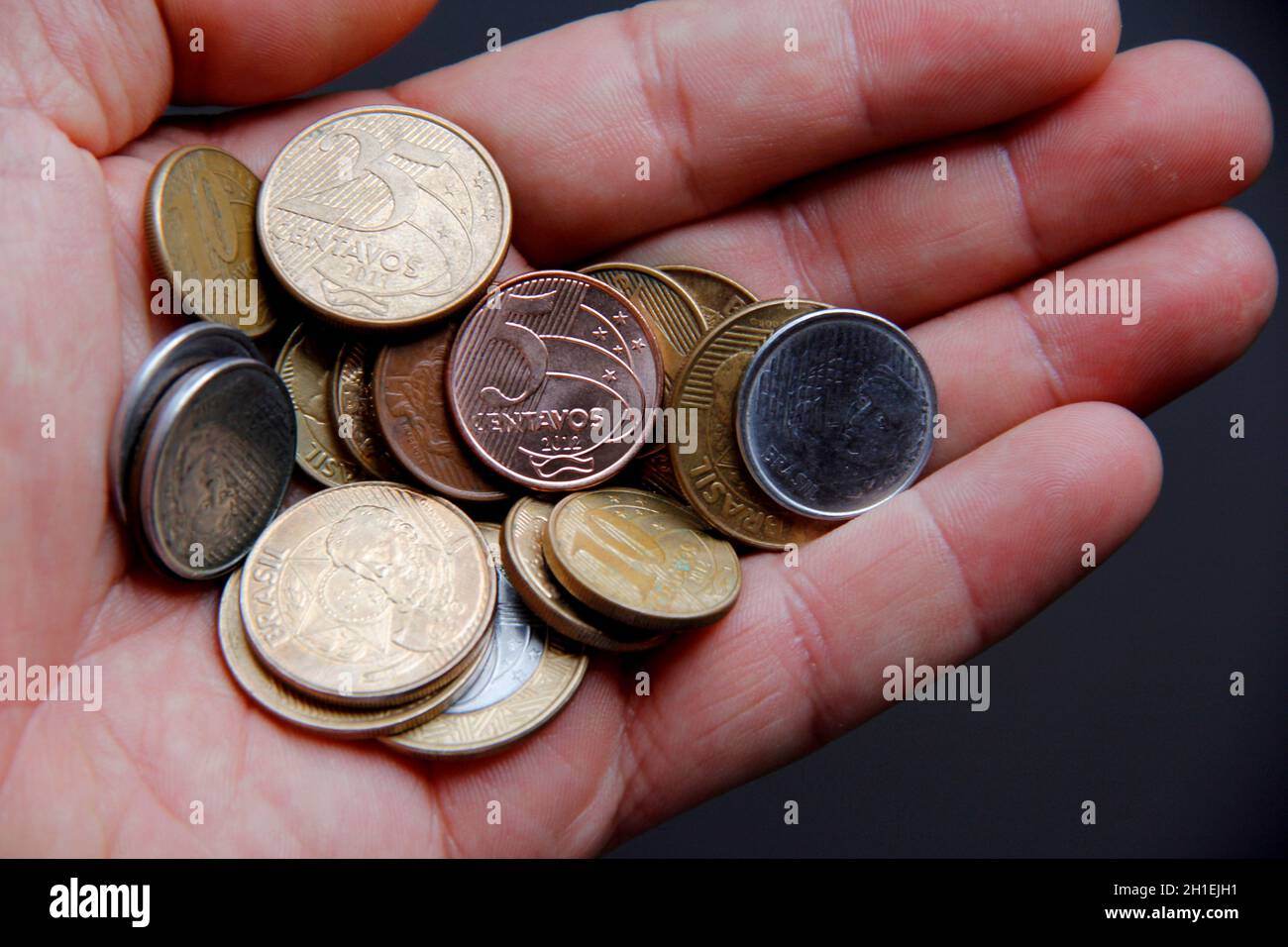 salvador, bahia / brasilien - 19. januar 2013: Hand hält echte Münzen, brasilianisches Geld. *** Ortsüberschrift *** Stockfoto