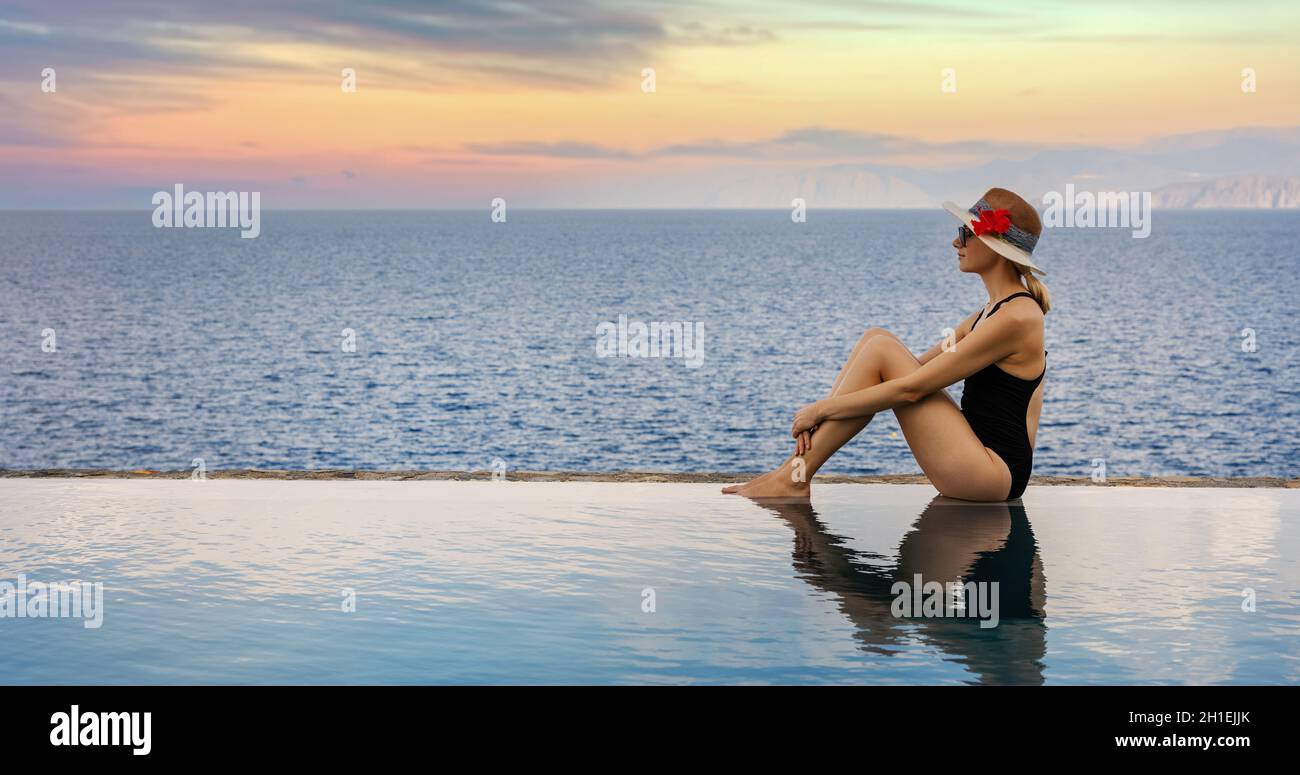 Frau, die sich am Rande des unendlichen Swimmingpools im Luxus-Resort entspannt. Sommerurlaub. Banner-Kopierraum Stockfoto