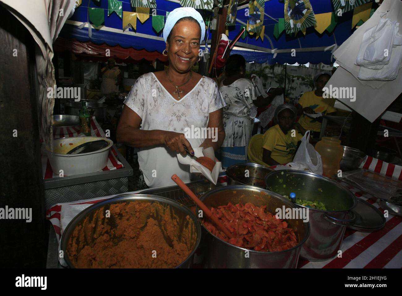 salvador, bahia / brasilien - 5. juni 2014: Jaciara de Jesus Santos, 'Cira', Bahian acaraje, bereitet die Speisen in einem Verkaufsbehälter im Viertel Itapua zu Stockfoto