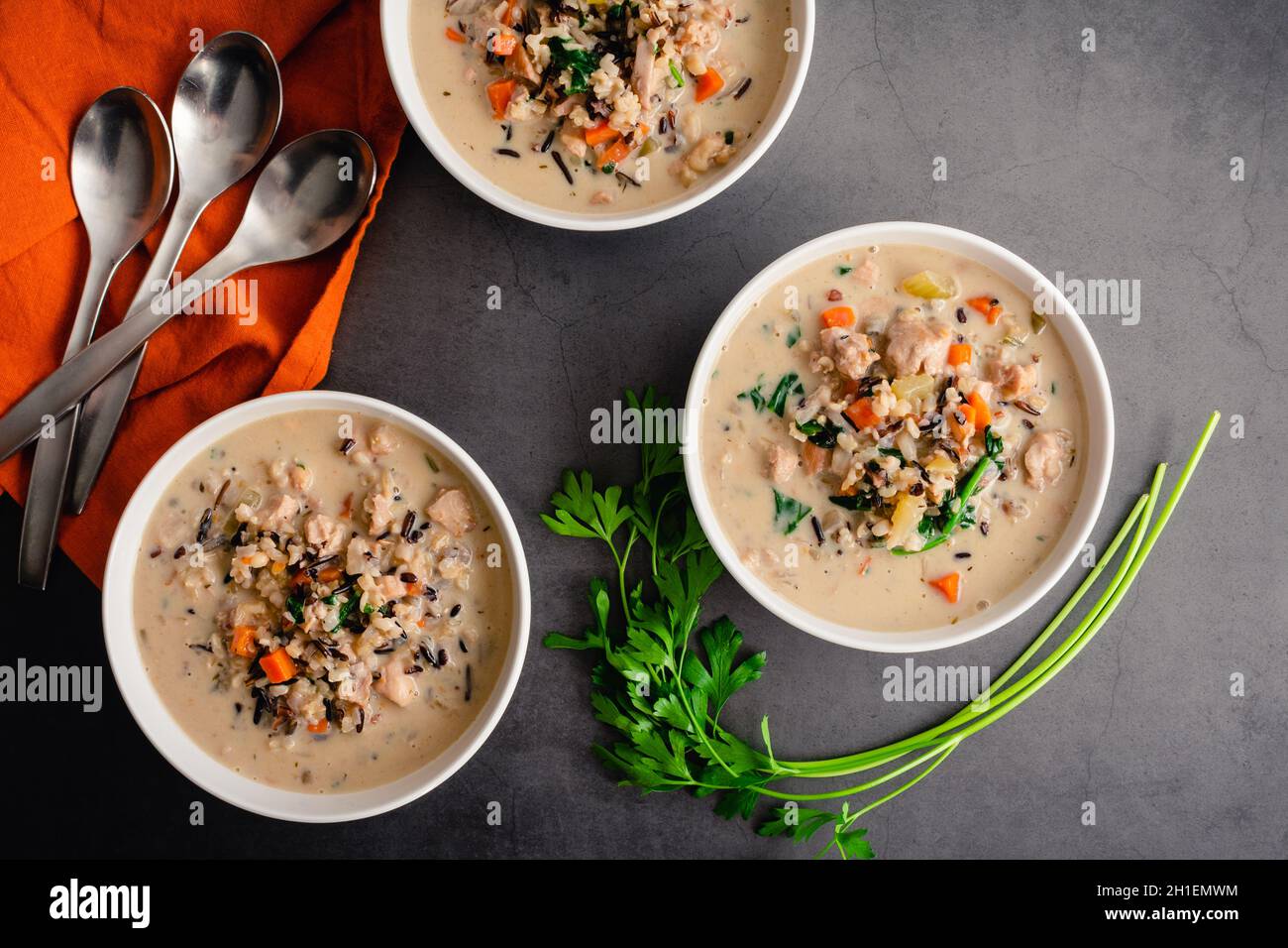 Schalen mit Hühnchen und Wildreis-Suppe: Blick von oben auf cremige Hühnchen- und Wildreissuppe mit Spinat und Karotten Stockfoto