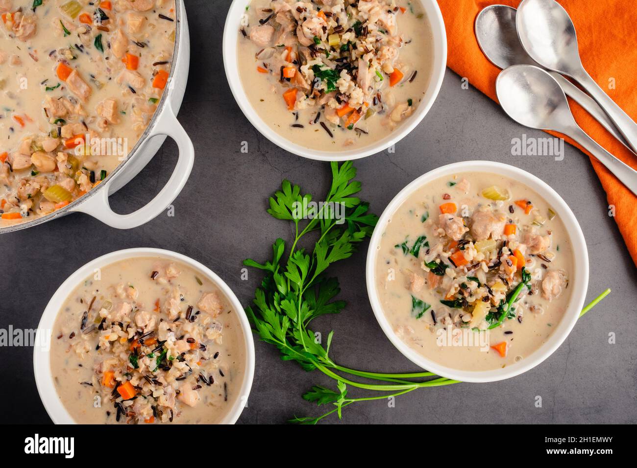 Schalen mit Hühnchen und Wildreis-Suppe: Blick von oben auf cremige Hühnchen- und Wildreissuppe mit Spinat und Karotten Stockfoto