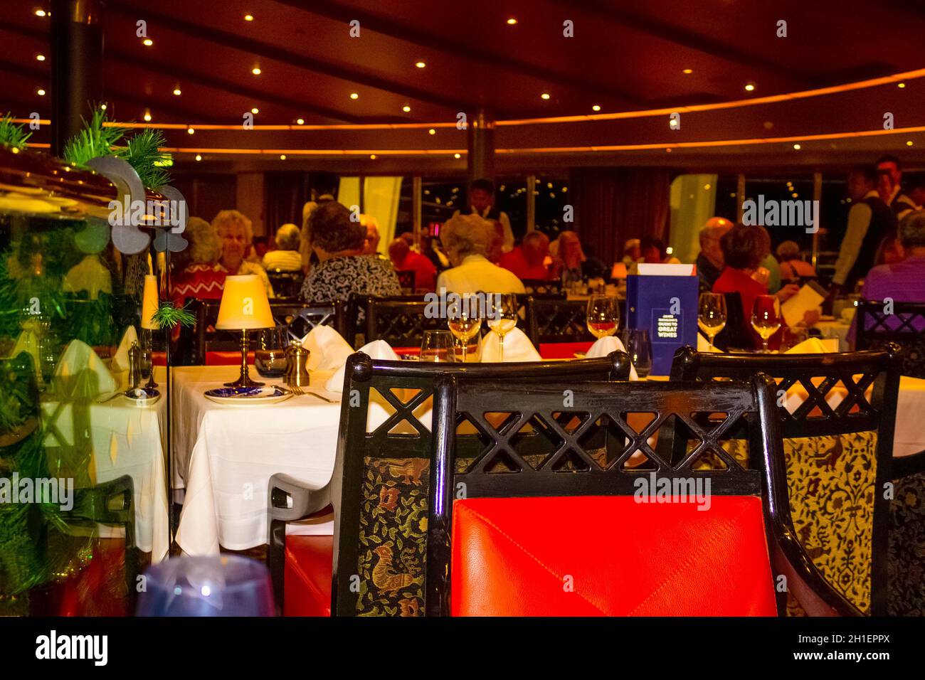 Willemstad, Curacao, Niederlande - 5. Dezember 2019: Die Leute beim Abendessen im Grande Restaurant und Tische mit Gerichten auf der luxuriösen Holland Amerika Kreuzfahrt Stockfoto