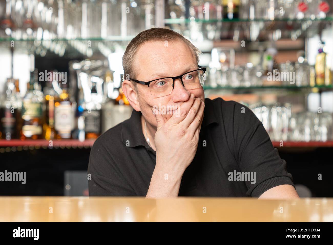 Ein Pub-Gastgeber sorgt sich, weil er keine Gäste in seinem Pub hat Stockfoto