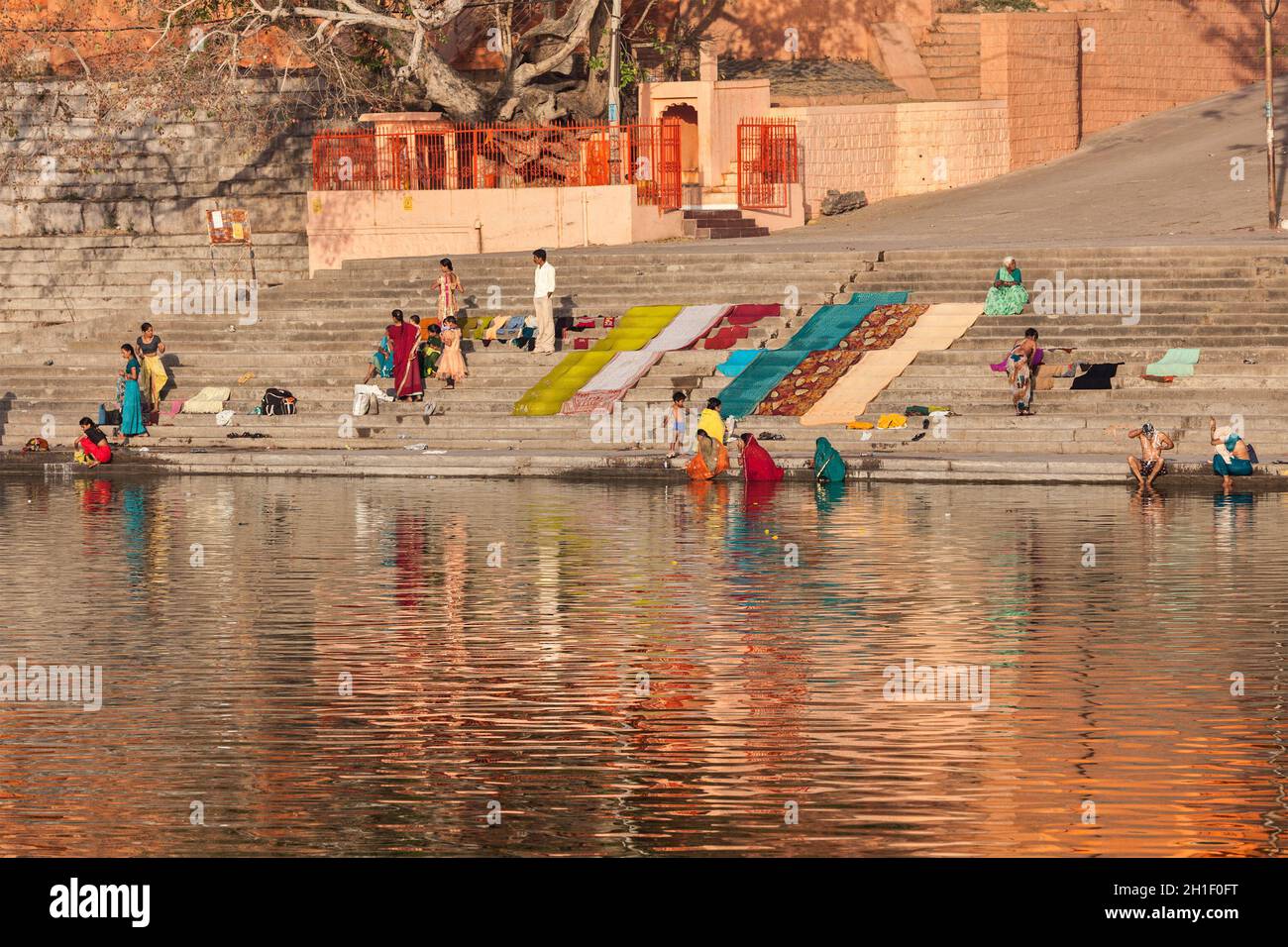 UJJAIN, INDIEN - 25. APRIL 2011: Morgens baden und waschen Menschen auf Ghats des heiligen Kshipra-Flusses Kleidung. Shipra ist einer der heiligen Flüsse i Stockfoto