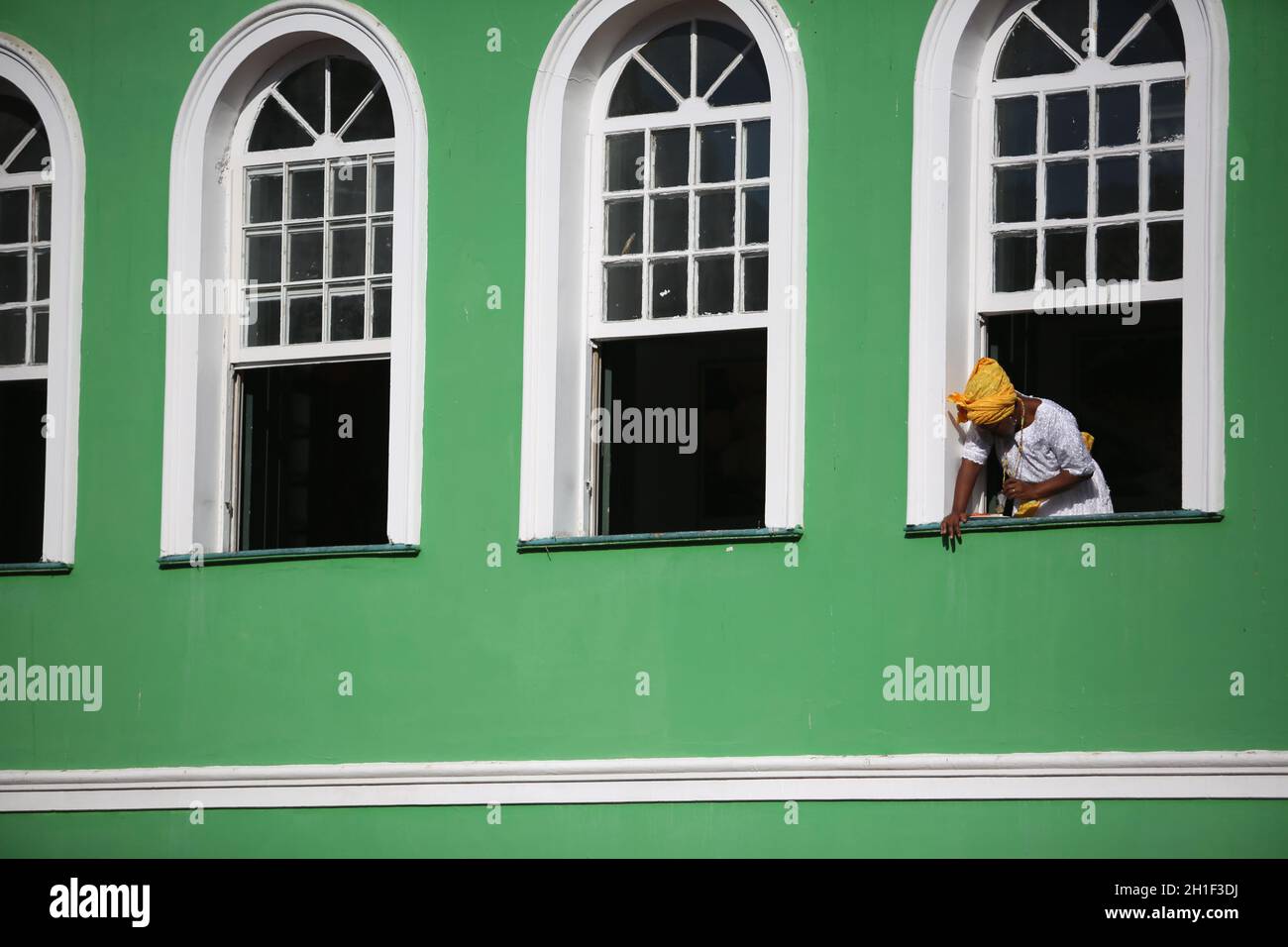 salvador, bahia / brasilien - 4. dezember 2017: Frau beobachtet die Straße vom Balkon eines Stadthauses im Viertel Pelourinhoin Salvador aus. *** Stockfoto