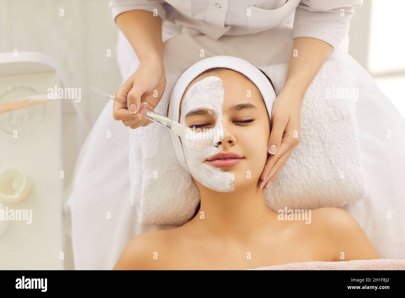 Kosmetologe tun Gesichtsmaske Frau Klientin Stockfoto