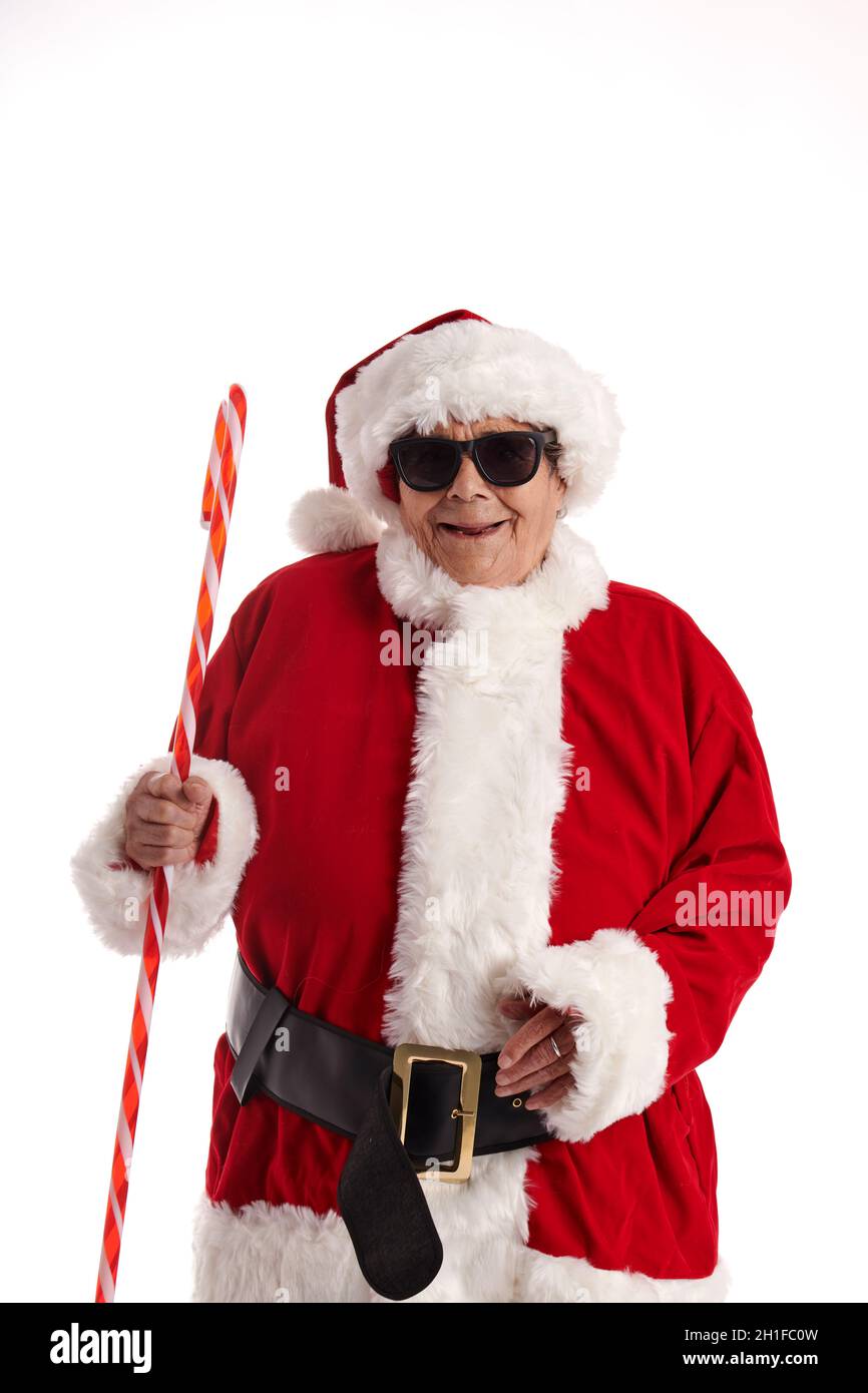 Eine ältere Frau, die als Weihnachtsmann gekleidet ist und eine Sonnenbrille auf weißem Hintergrund trägt. Stockfoto