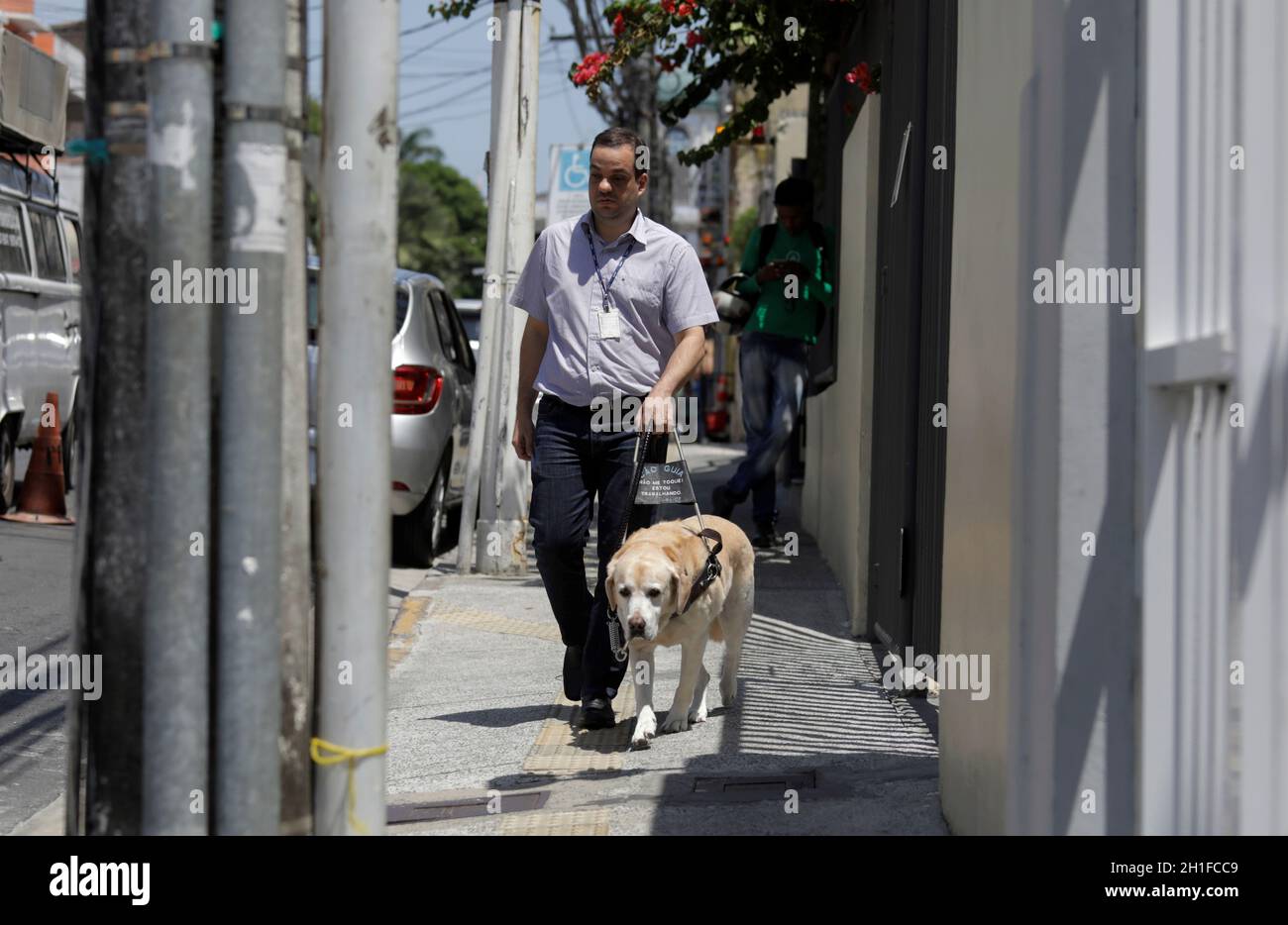 salvador, bahia / brasilien - 20. märz 2019: Sehbehinderte nutzen seinen Blindenhund, um in der Nachbarschaft von Nazare in salvador City herumzukommen. *** Loca Stockfoto