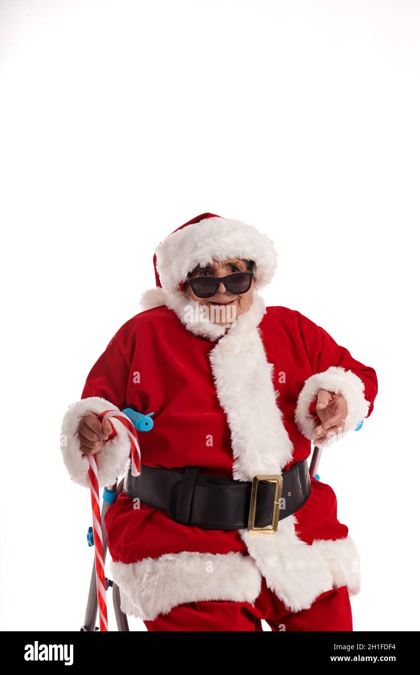 Ein Nonagenist, der als Weihnachtsmann gekleidet ist, lacht und schaut auf die Kamera. Stockfoto