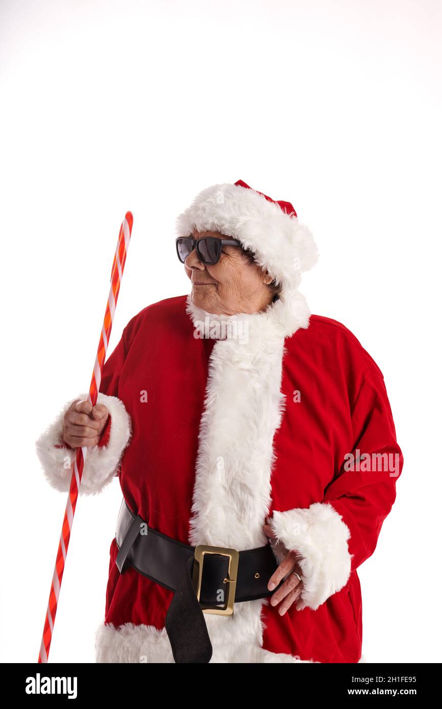 Ältere Frau als Weihnachtsmann mit Sonnenbrille auf weißem Hintergrund Stockfoto
