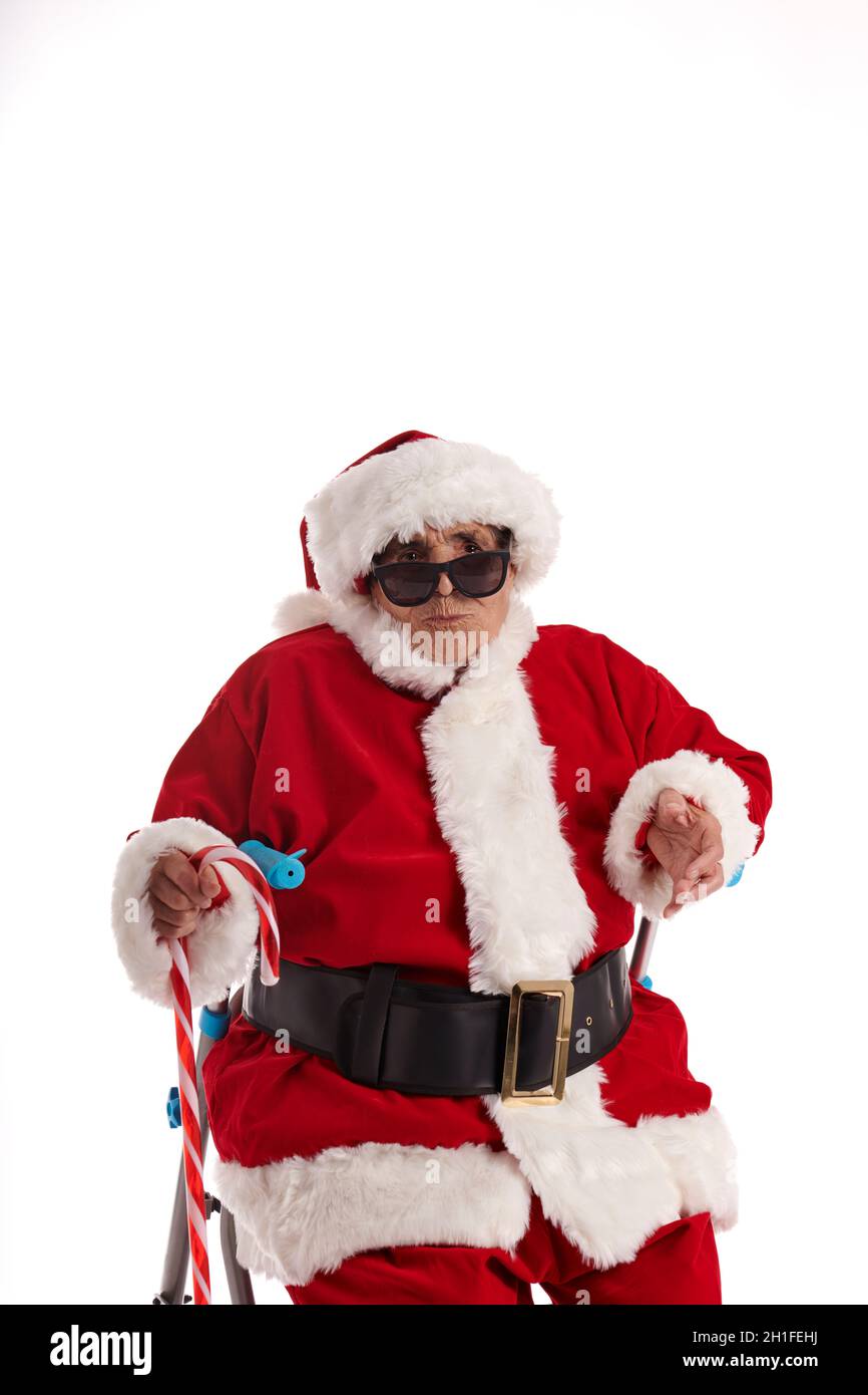 Ein Nonagenist, der sich als Weihnachtsmann verkleidet hat, einen Kuss gibt und die Kamera anschaut. Stockfoto
