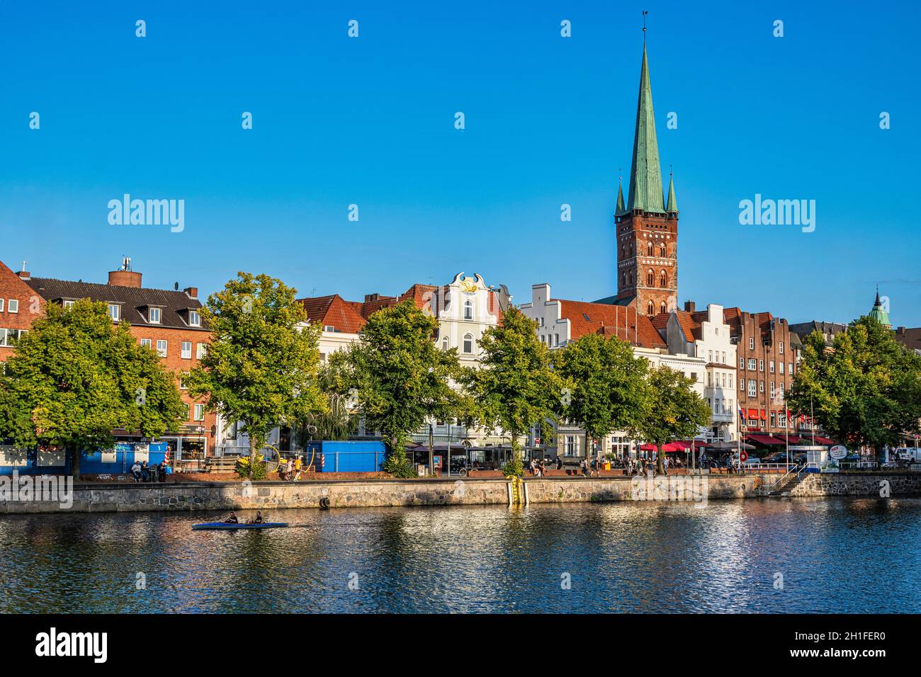 Typische Häuser der Stadt Lübeck mit Blick auf die Trace. Über den Dächern der Häuser erhebt sich der Glockenturm der Kirche San Pietro. Stockfoto