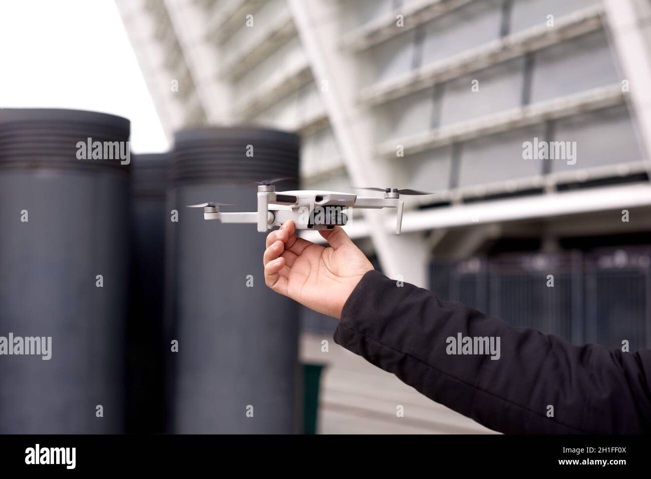 Die Hand des Mannes hält die Drohne vor dem Start auf der Stadtstraße Stockfoto