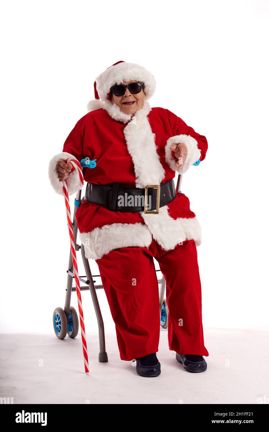 Ein Nonagenist in einem Weihnachtsmann-Kostüm, der auf einem Spaziergänger mit weißem Hintergrund sitzt. Stockfoto