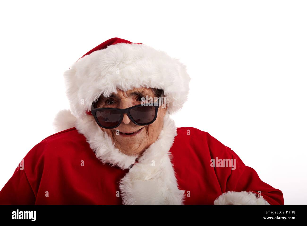 Nahaufnahme einer alten Frau im Weihnachtsmann Kostüm mit Sonnenbrille auf weißem Hintergrund Stockfoto