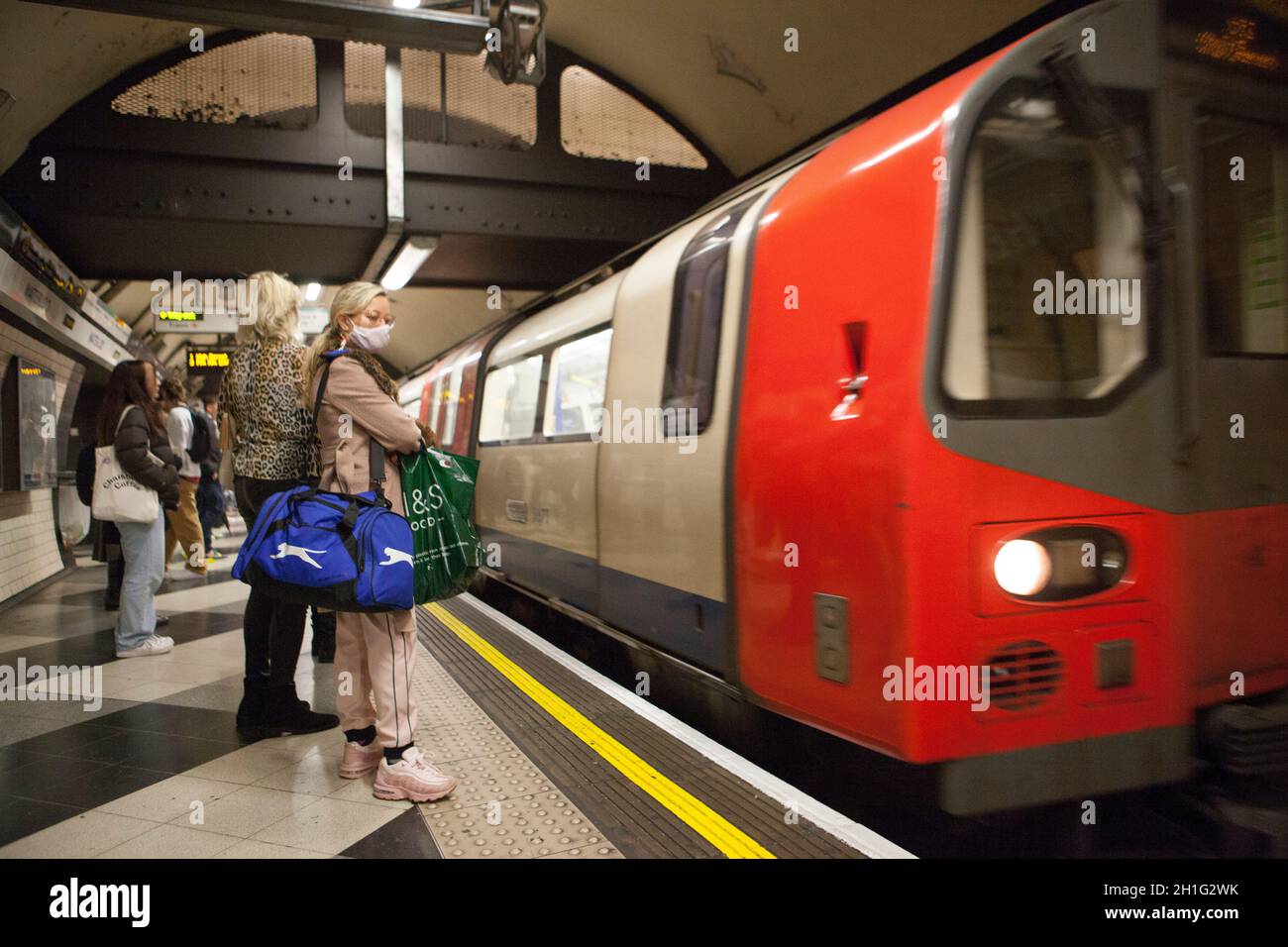 London, Großbritannien, 18 Uhr 2021: Menschen, die mit Gesichtsmasken in der Londoner U-Bahn unterwegs sind. Gesichtsbezüge sind in London für den öffentlichen Nahverkehr obligatorisch, werden aber nicht von allen an U-Bahn- und nicht an Bussen getragen. Obwohl einige Menschen eine medizinische Ausnahme haben, ist der Anteil der Menschen, die ohne sie gehen, viel höher, als medizinische Gründe erklären können. Anna Watson/Alamy Live News Stockfoto