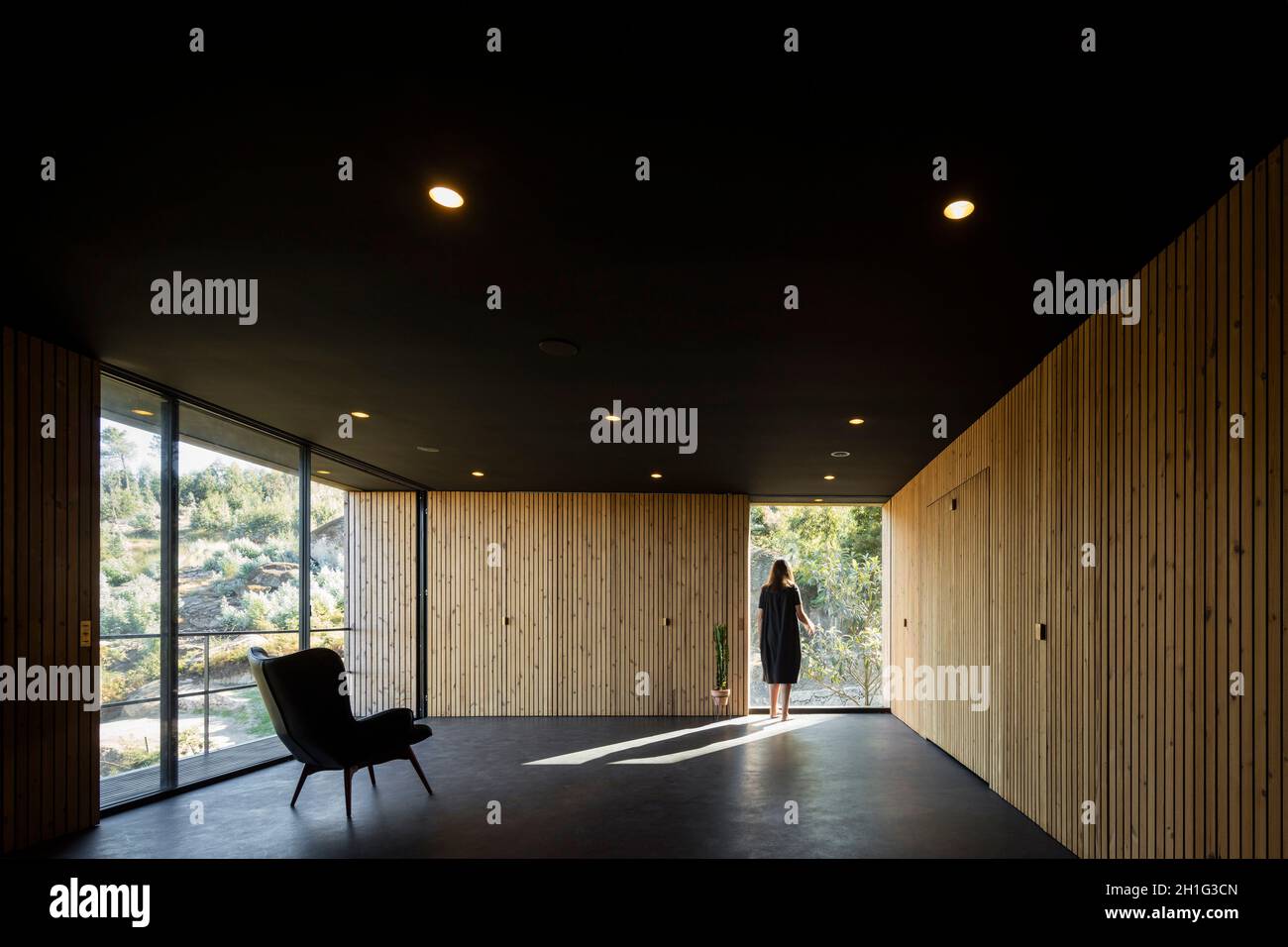 Zentraler Raum und stehende Figur. Pavilion House, Guimarães, Portugal. Architekt: Diogo Aguiar Studio, 2019. Stockfoto