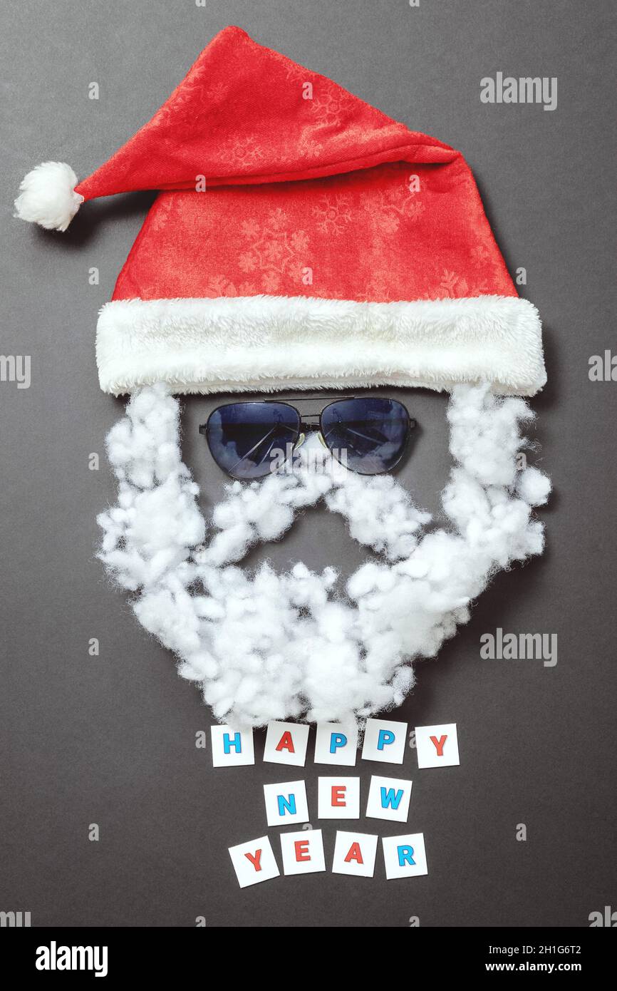 Samt Santa Hut mit Sonnenbrille Schnurrbart und Bart und Inschrift Frohes neues Jahr. Das Gesicht des Weihnachtsmanns. Urlaubspostkarte Stockfoto